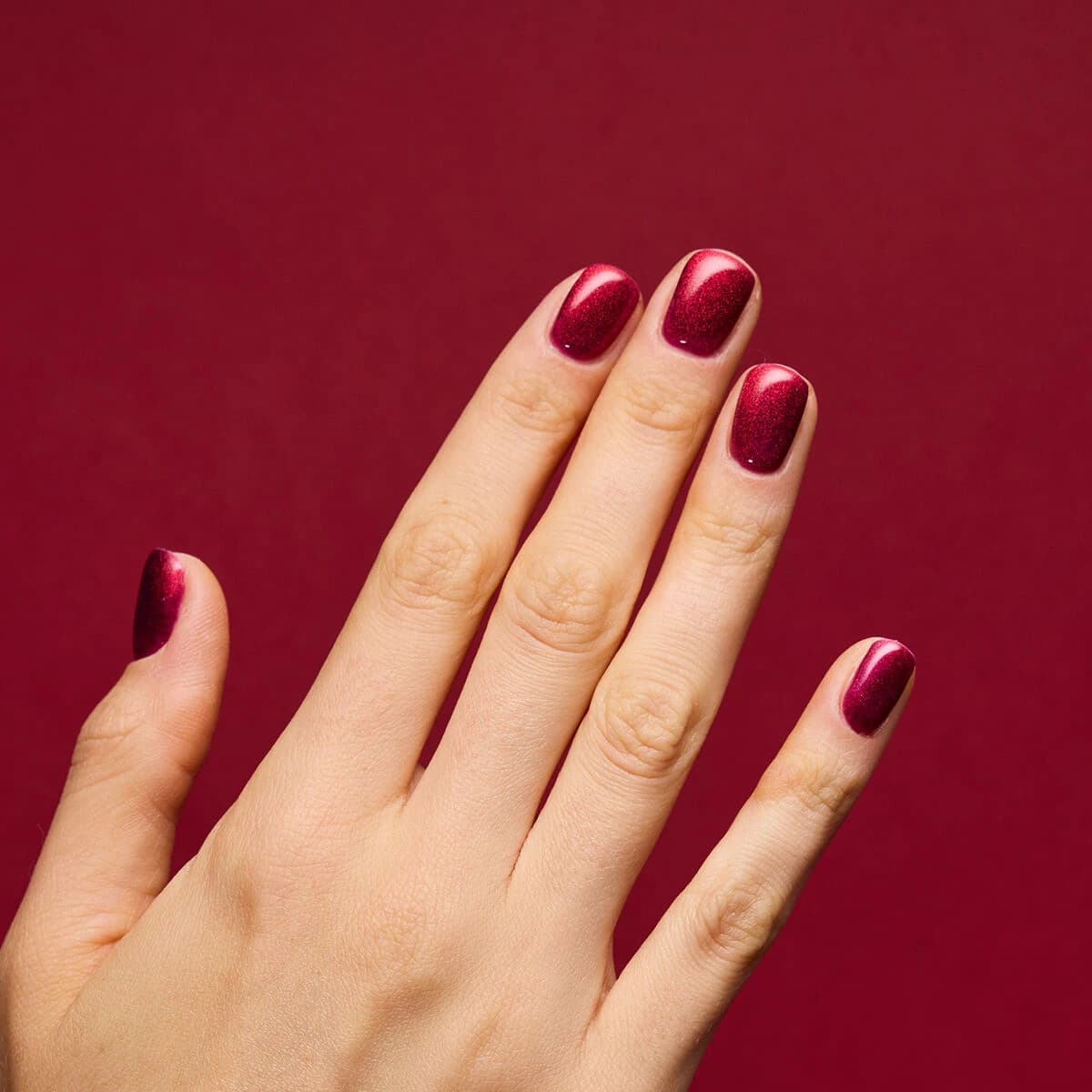 Manucure avec le vernis semi-permanent 955 Holly Berry Red de Semilac, un rouge foncé pailleté.