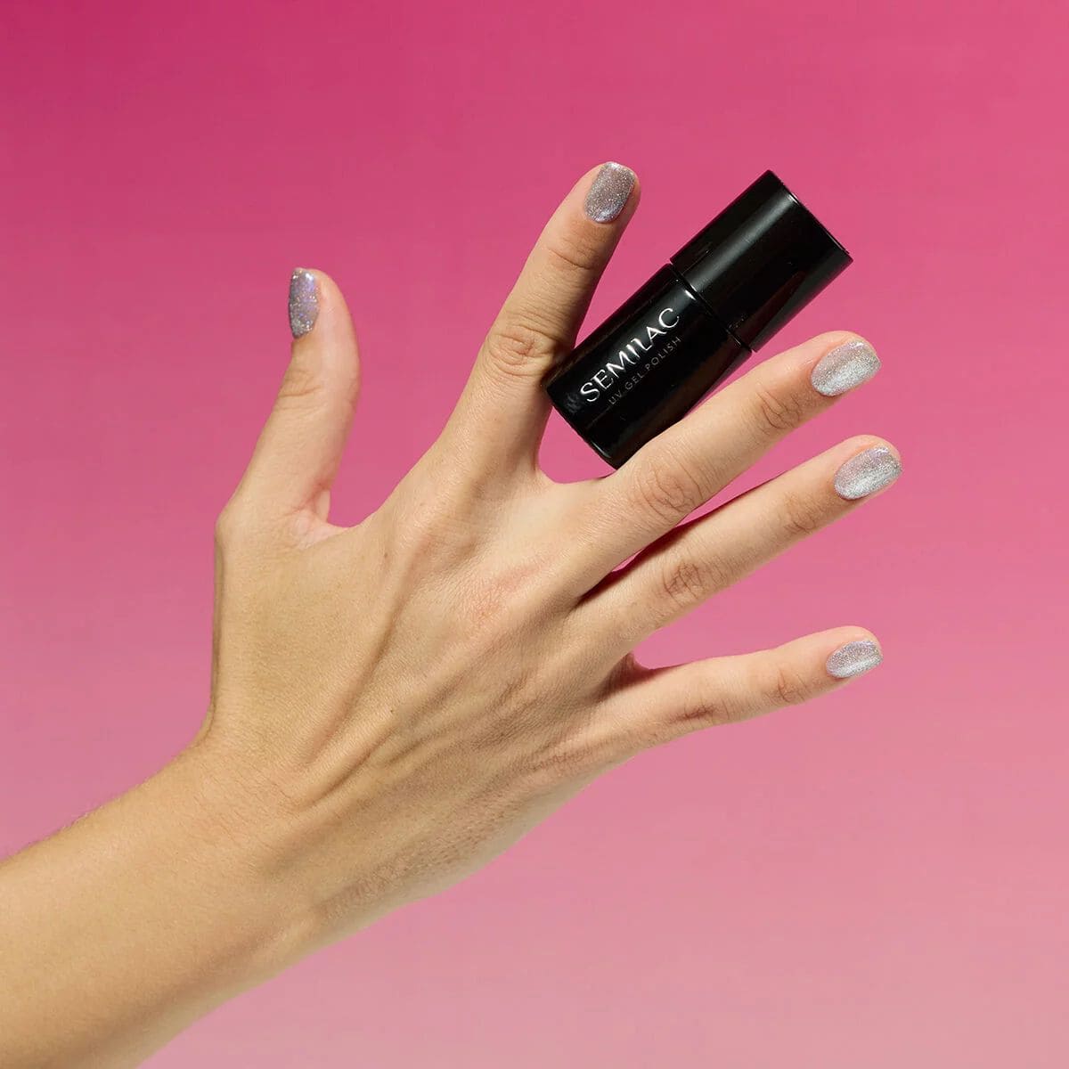 Flacon et manucure du Vernis semi-permanent Semilac 961 Magnetic Flash, un semi-transparent argenté avec des paillettes reflectives.